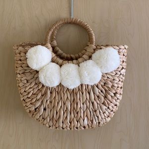 Weaved purse with pom-poms